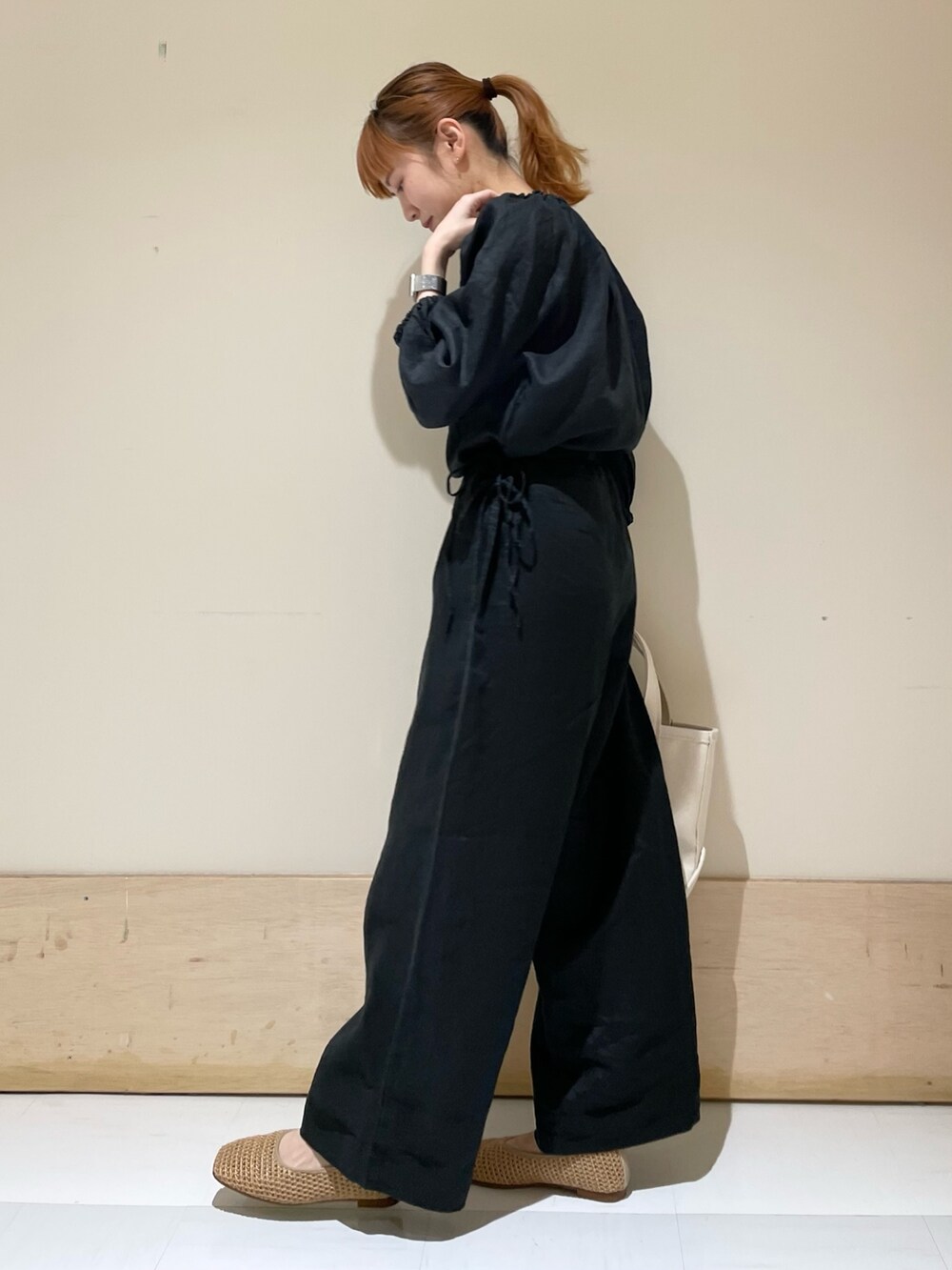 ブラック系のサロペット/オーバーオール、ベージュ系のバレエシューズ、ホワイト系のトートバッグを着用したレディースの春コーディネートの4枚目の写真