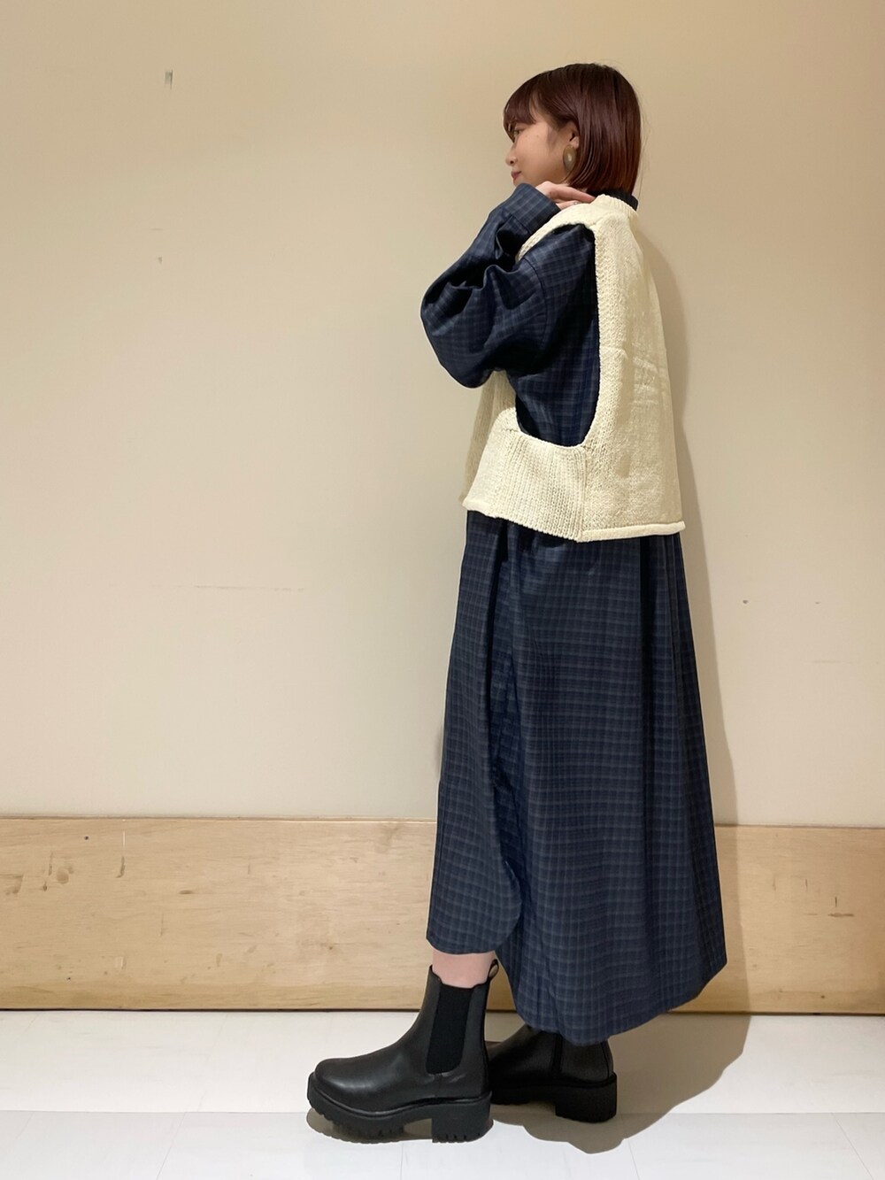 ホワイト系のベスト、グレー系のシャツワンピース、ブラック系のトートバッグを着用したレディースの秋コーディネートの4枚目の写真