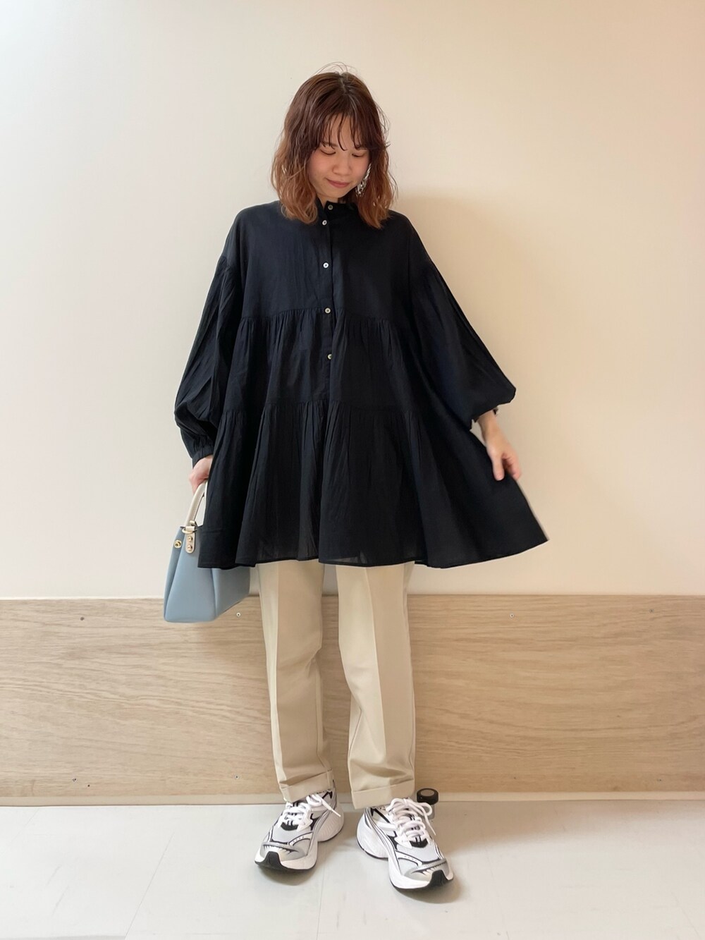 ブラック系のチュニック、ベージュ系のその他パンツを着用したレディースの春コーディネートの2枚目の写真