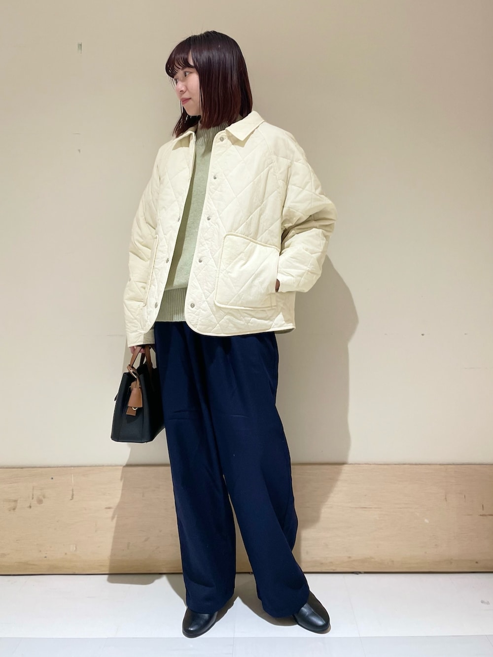 グリーン系のニット/セーター、ホワイト系のダウンジャケット/コート、ブルー系のその他パンツを着用したレディースの冬コーディネートの3枚目の写真