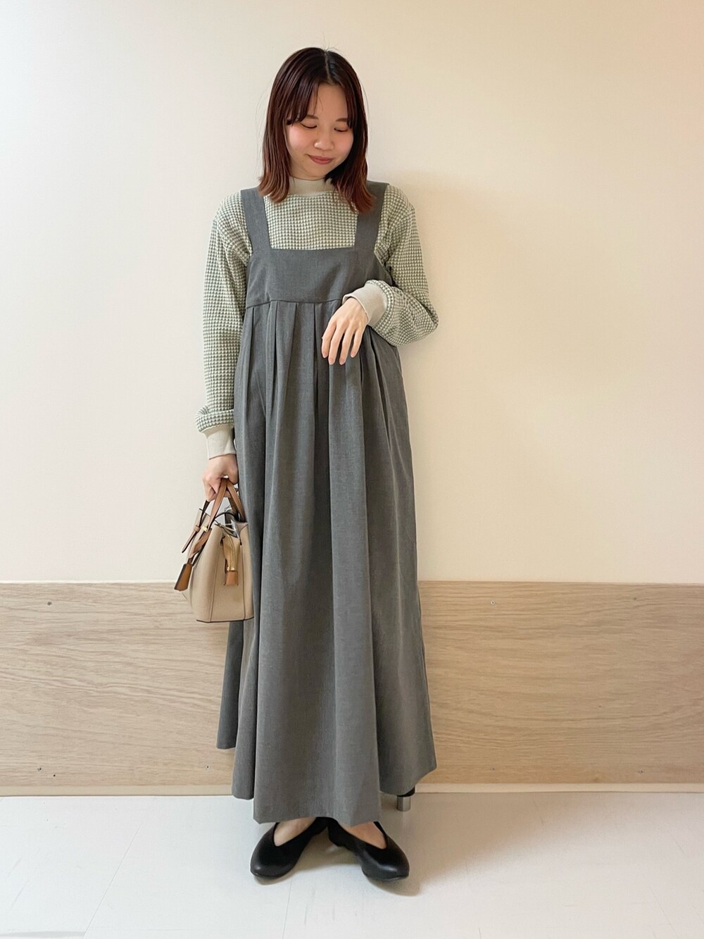 ブラック系のパンプス、グレー系のワンピース、グリーン系のTシャツ/カットソーを着用したレディースの春コーディネートの3枚目の写真