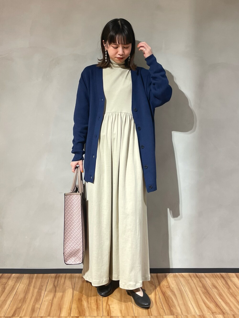 ベージュ系のワンピース、ブルー系のカーディガン/ボレロ、ブラック系のパンプスを着用したレディースの秋コーディネートの2枚目の写真