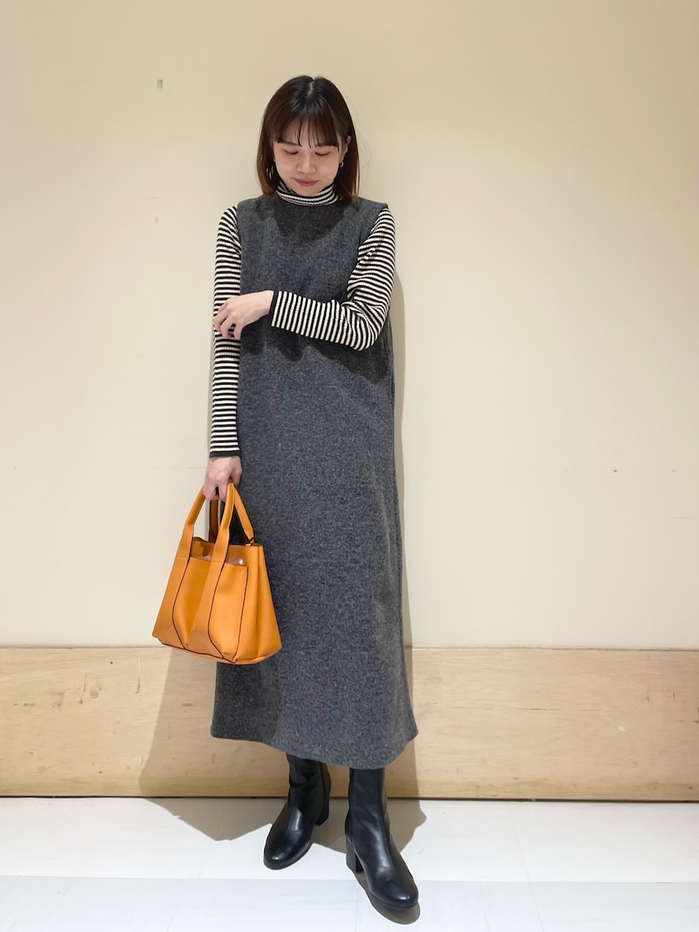 ホワイト系のニット/セーター、グレー系のワンピースを着用したレディースの冬コーディネートの4枚目の写真