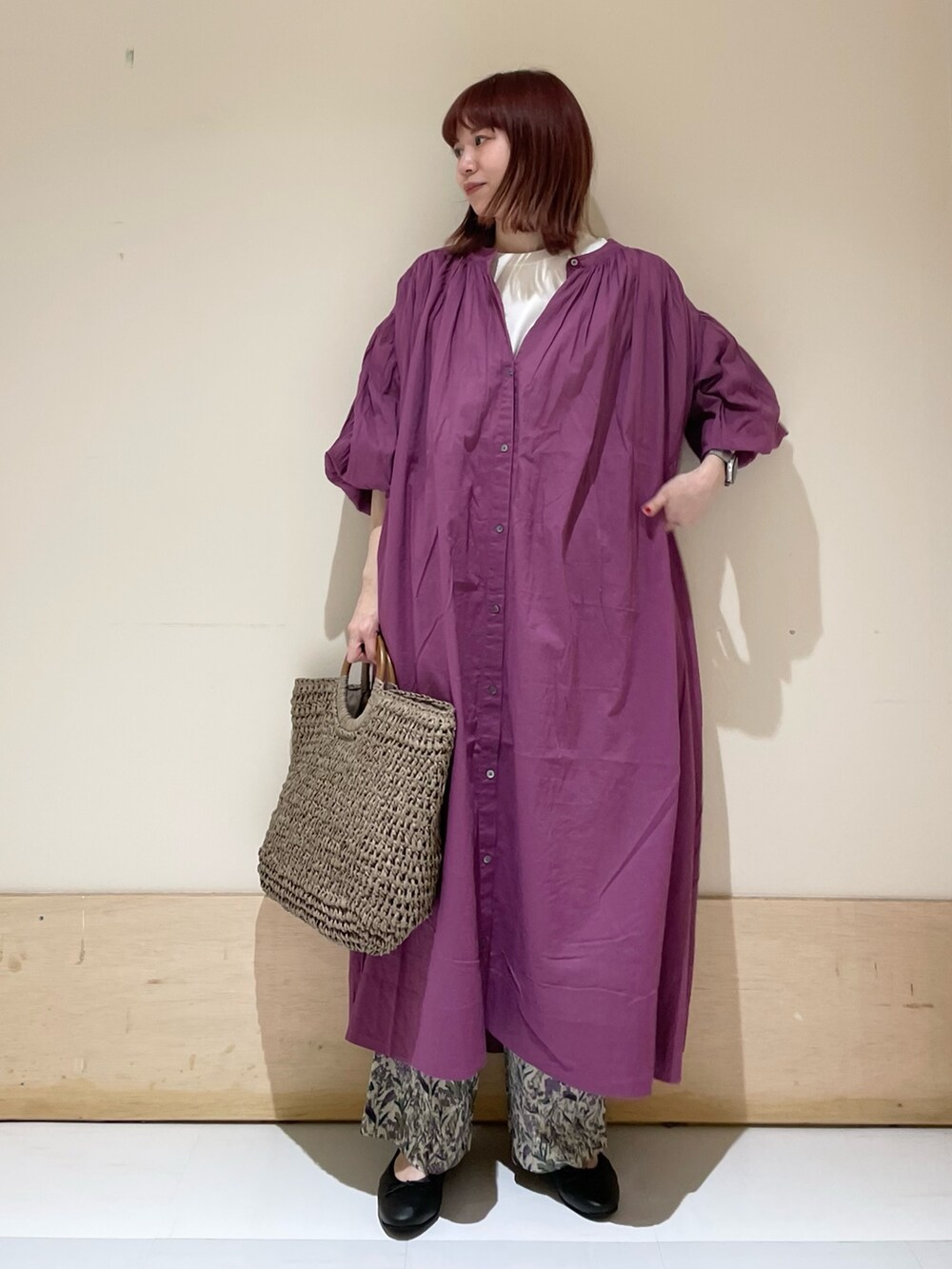 パープル系のワンピース、グレー系のかごバッグ、パープル系のその他パンツを着用したレディースの春コーディネートの2枚目の写真