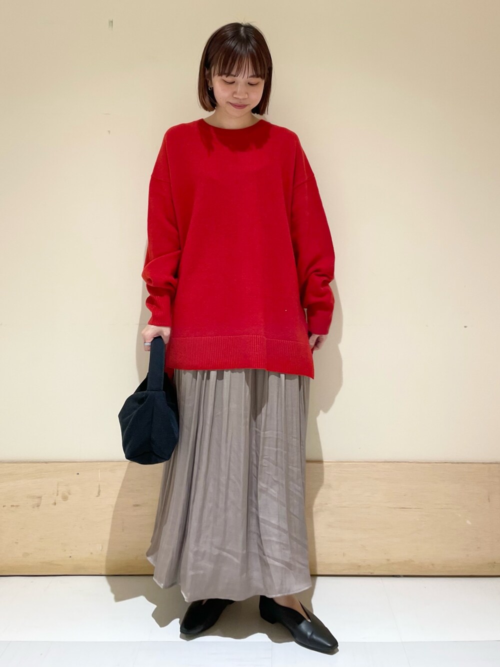 ブラック系のハンドバッグ、グレー系のスカート、ブラック系のパンプスを着用したレディースの秋コーディネートの3枚目の写真