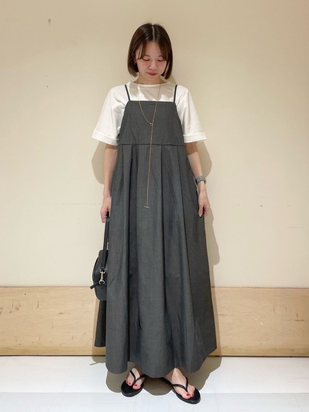 ブラック系のワンピース、ブラック系のショルダーバッグ、ブラック系のサンダルを着用したレディースの夏コーディネートの2枚目の写真