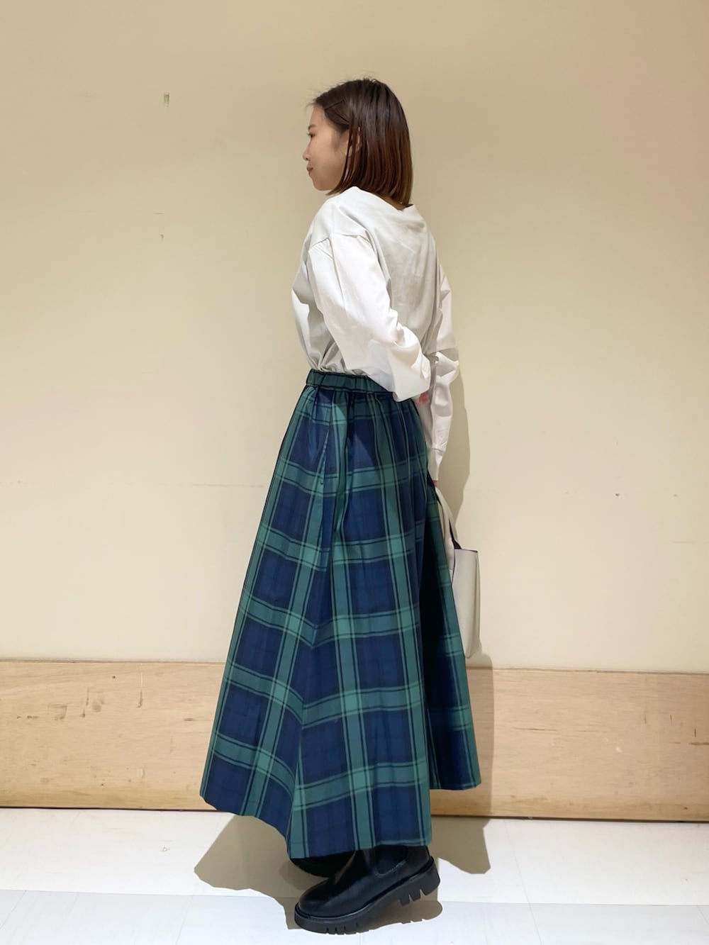 グレー系のTシャツ/カットソー、ブルー系のスカート、グレー系のトートバッグを着用したレディースの秋コーディネートの3枚目の写真