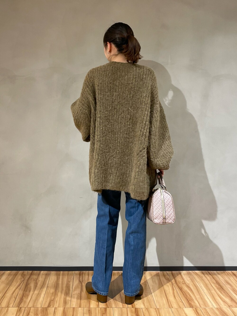 ブラウン系のニット/セーター、ブルー系のデニムパンツ、イエロー系のブーツを着用したレディースの秋コーディネートの3枚目の写真