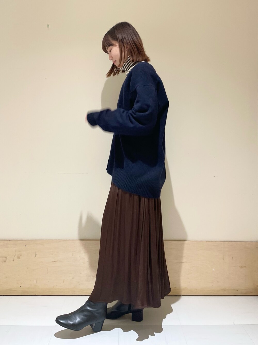 ブルー系のカーディガン/ボレロ、ホワイト系のニット/セーター、ブラウン系のスカートを着用したレディースの冬コーディネートの4枚目の写真