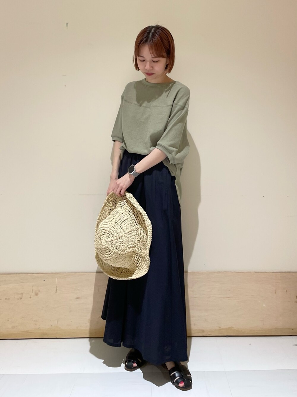 ブルー系のスカート、ブラック系のサンダル、グリーン系のTシャツ/カットソーを着用したレディースの春コーディネートの4枚目の写真