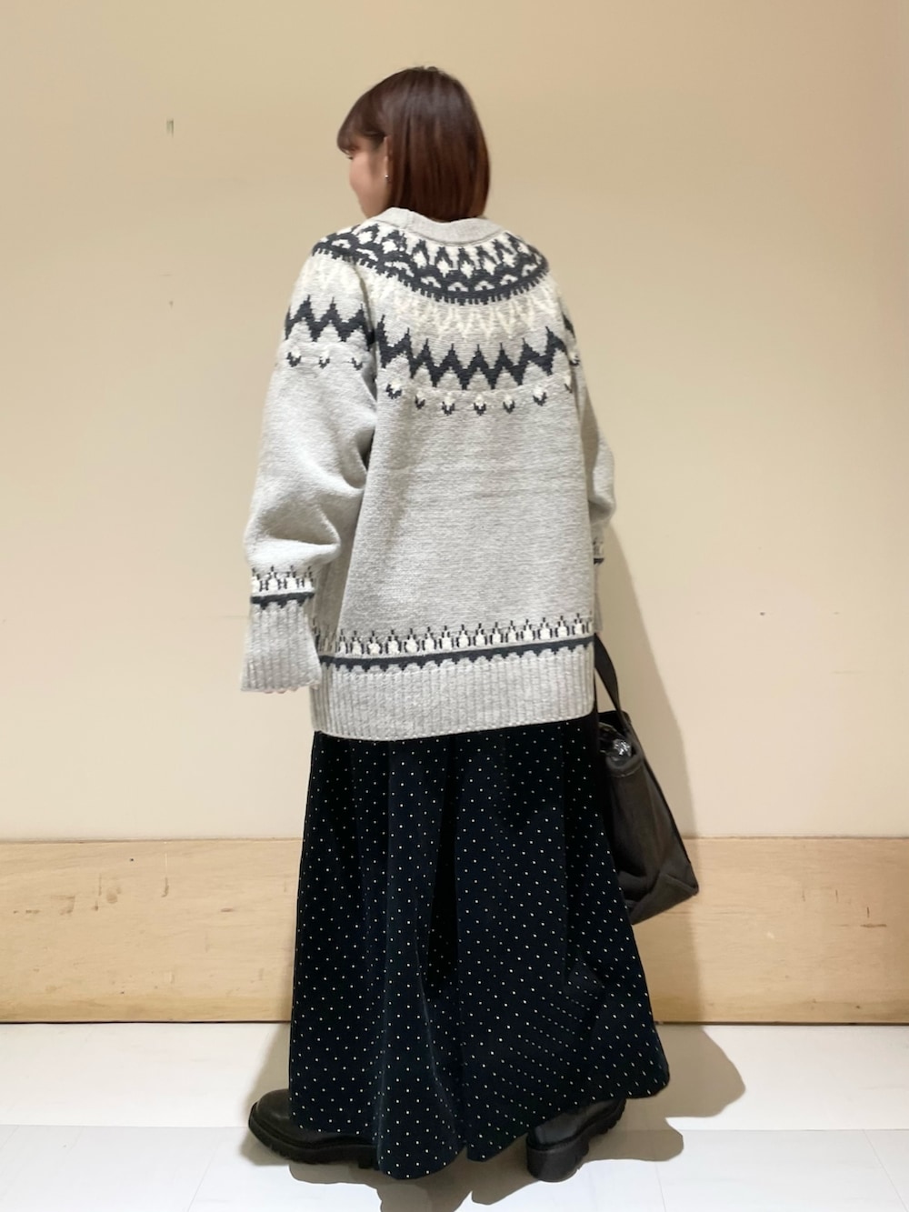 グレー系のニット/セーター、ブラック系のブーツ、ブラウン系のトートバッグを着用したレディースの秋コーディネートの6枚目の写真