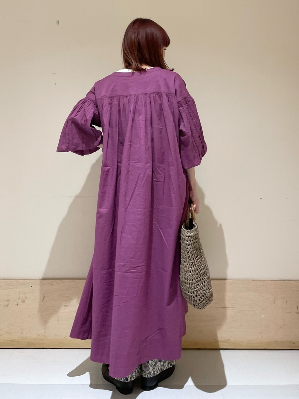 パープル系のワンピース、グレー系のかごバッグ、パープル系のその他パンツを着用したレディースの春コーディネートの7枚目の写真