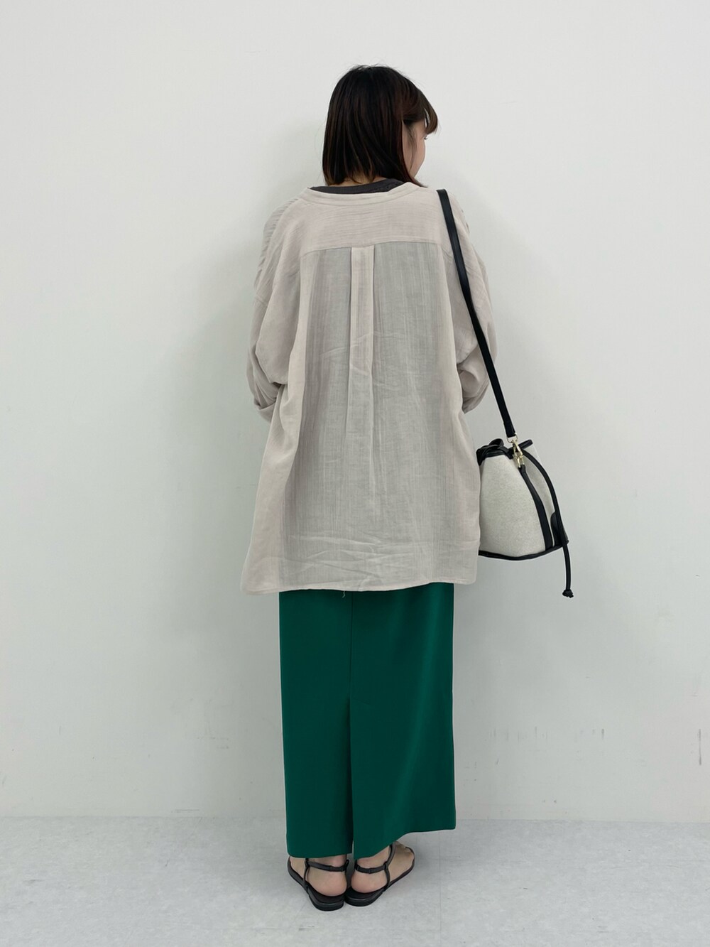 ブラック系のサンダル、グリーン系のスカート、グレー系のニット/セーターを着用したレディースの夏コーディネートの3枚目の写真