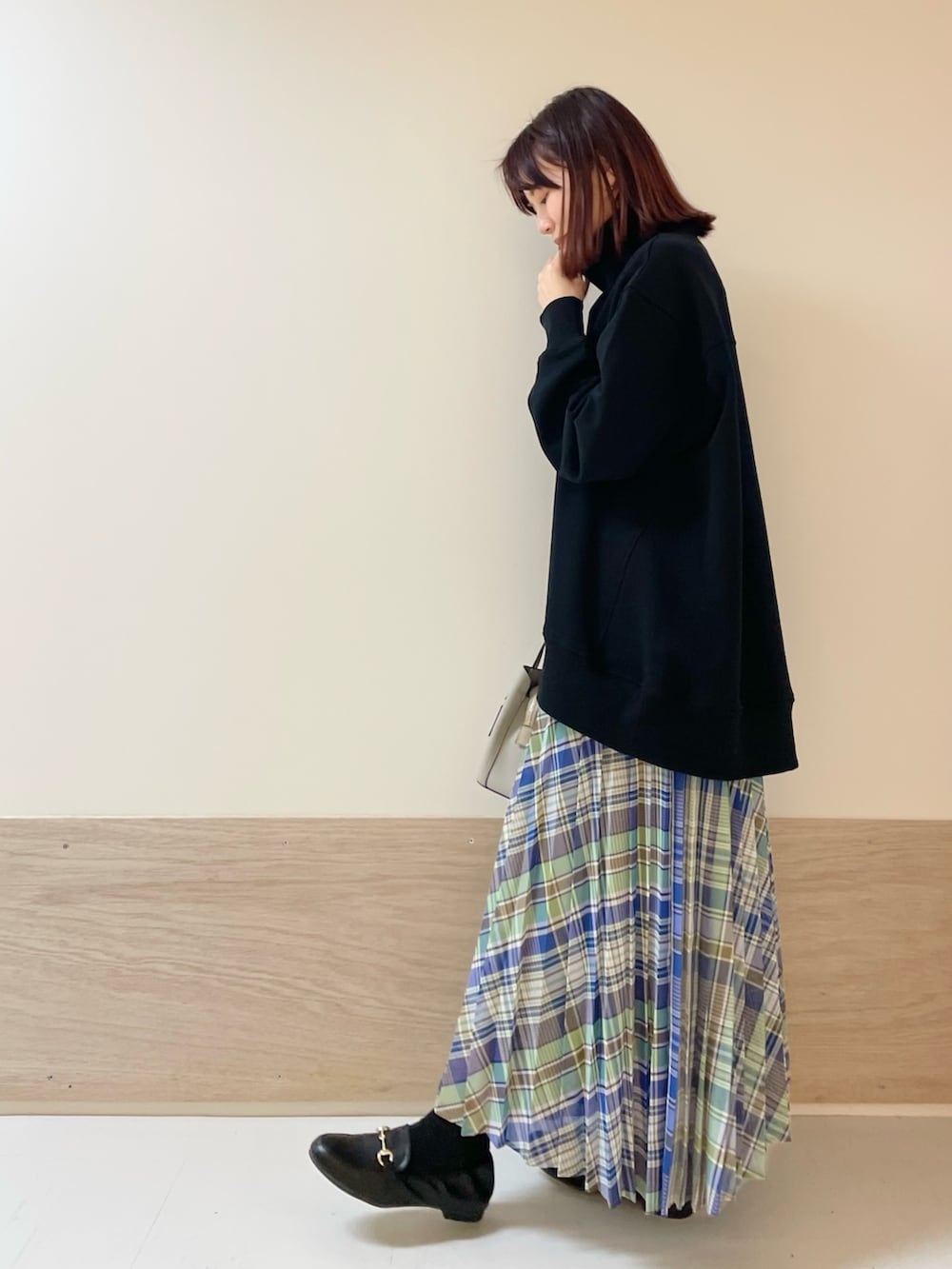 グリーン系のスカート、ブラック系のスウェットを着用したレディースの春コーディネートの5枚目の写真
