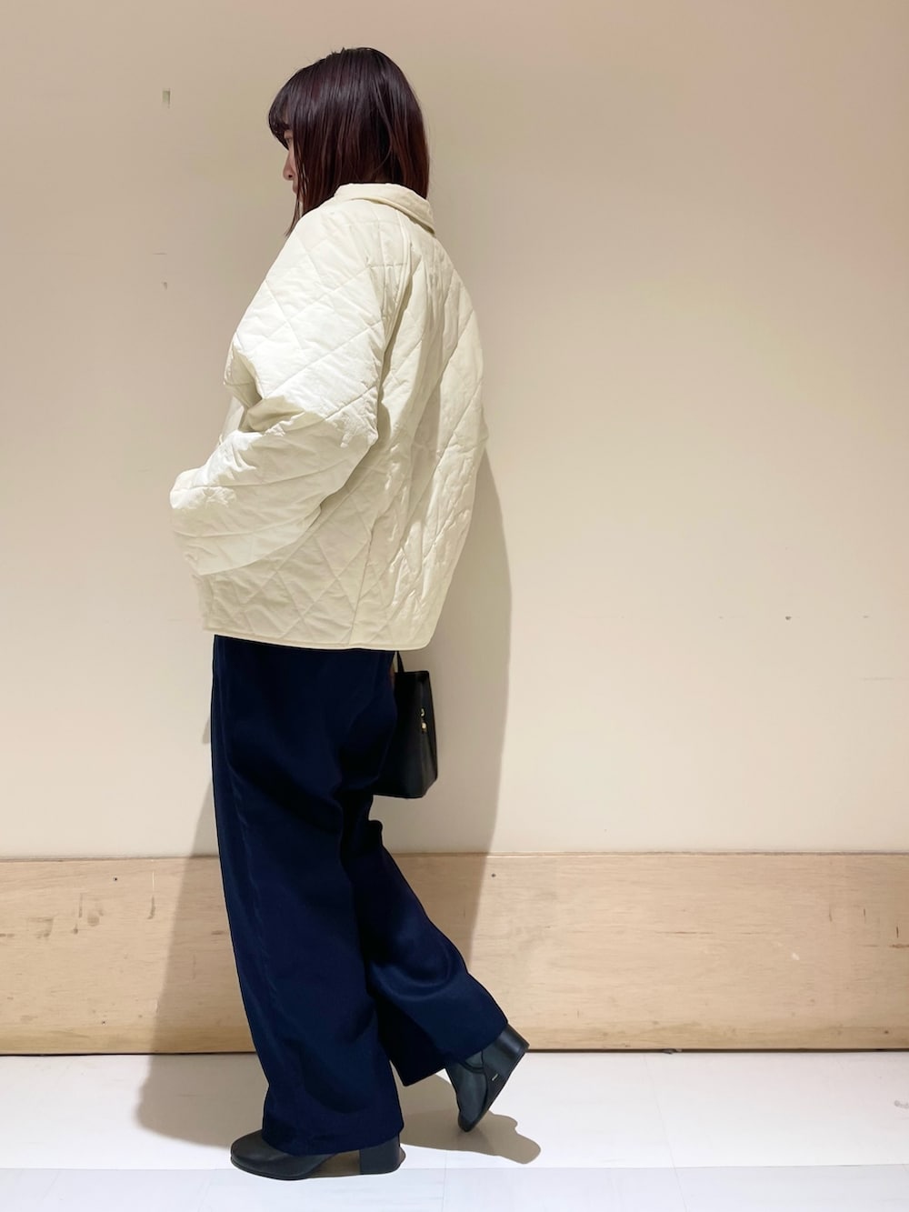 グリーン系のニット/セーター、ホワイト系のダウンジャケット/コート、ブルー系のその他パンツを着用したレディースの冬コーディネートの6枚目の写真