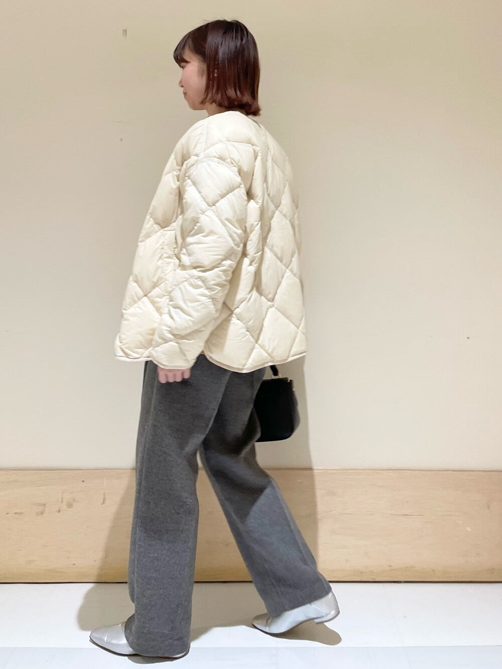 イエロー系のニット/セーター、グレー系のその他パンツ、ブラック系のショルダーバッグを着用したレディースの秋コーディネートの5枚目の写真