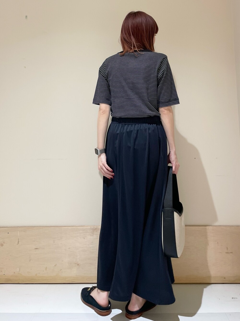 ブルー系のその他シューズ、ブルー系のスカート、ブラック系のハンドバッグを着用したレディースの春コーディネートの7枚目の写真