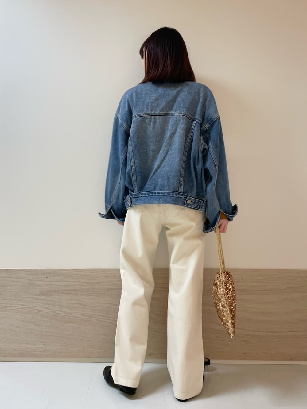 イエロー系のニット/セーター、ベージュ系のデニムパンツ、ブルー系のデニムジャケットを着用したレディースの冬コーディネートの5枚目の写真