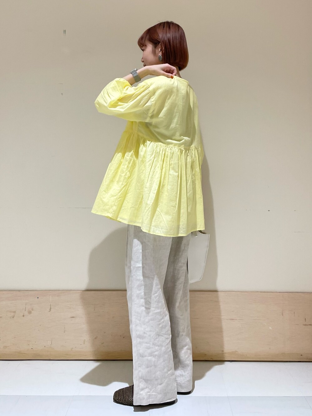 ベージュ系のその他パンツ、イエロー系のシャツ/ブラウス、ホワイト系のトートバッグを着用したレディースの春コーディネートの5枚目の写真