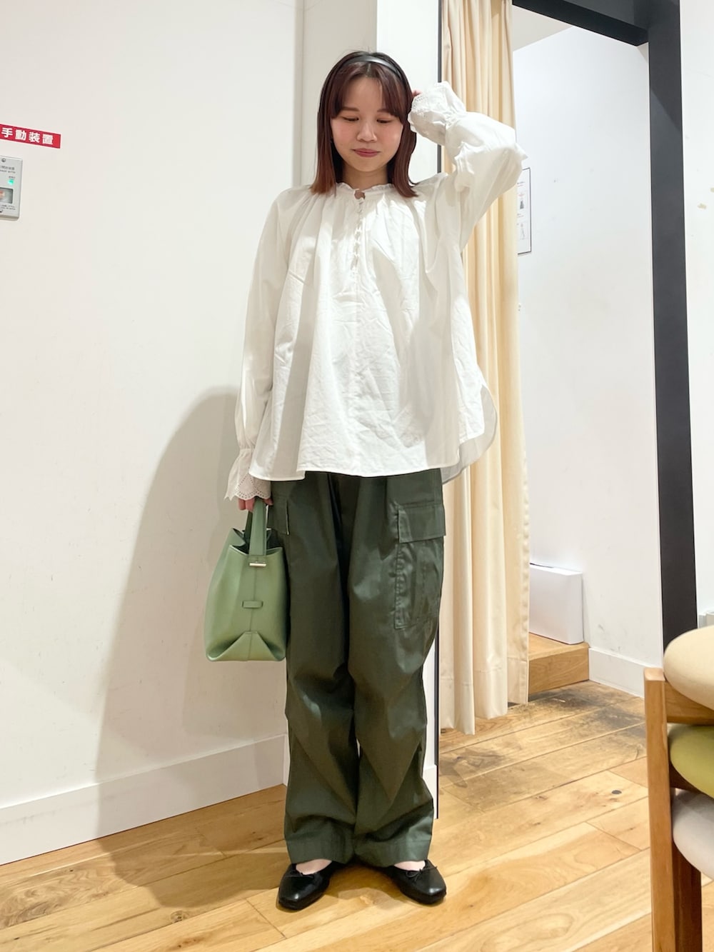 ホワイト系のシャツ/ブラウス、グリーン系のショルダーバッグ、ブラック系のバレエシューズを着用したレディースの春コーディネートの2枚目の写真