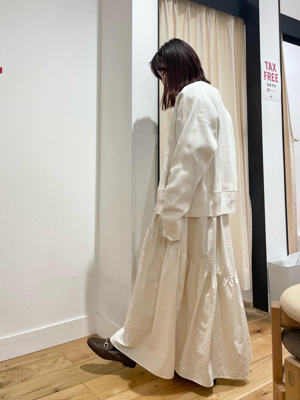 ホワイト系のカーディガン/ボレロ、ブラック系のTシャツ/カットソー、ホワイト系のスカートを着用したレディースの春コーディネートの4枚目の写真