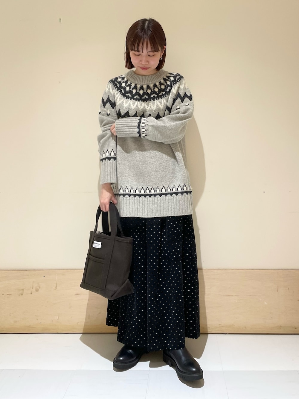 グレー系のニット/セーター、ブラック系のブーツ、ブラウン系のトートバッグを着用したレディースの秋コーディネートの4枚目の写真