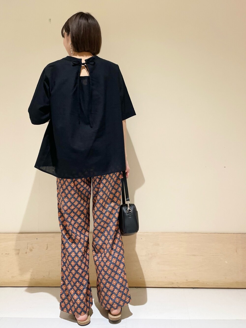 ブラック系のサンダル、ブラック系のショルダーバッグ、ブルー系のその他パンツを着用したレディースの夏コーディネートの6枚目の写真