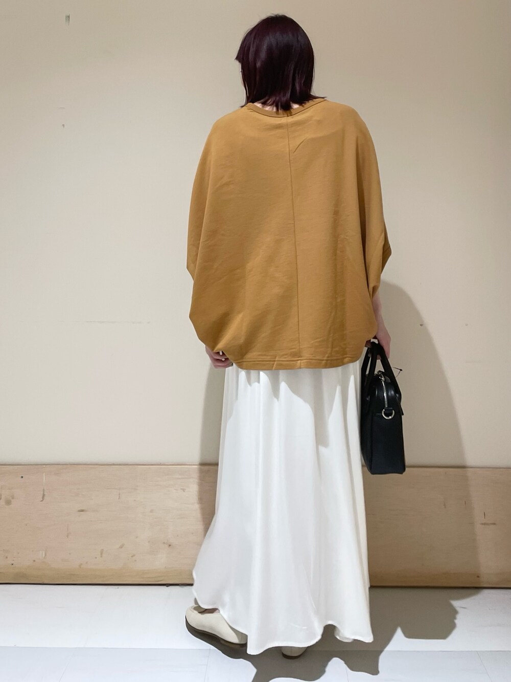 ホワイト系のスカート、イエロー系のTシャツ/カットソー、ブラック系のショルダーバッグを着用したレディースの春コーディネートの6枚目の写真