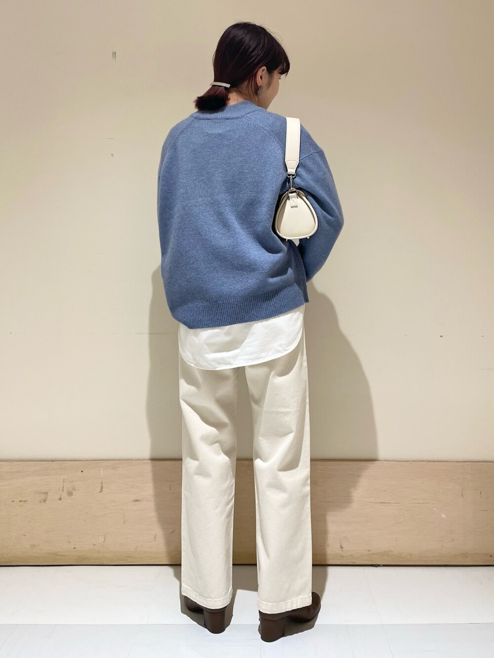 ベージュ系のデニムパンツ、ブルー系のニット/セーター、ホワイト系のショルダーバッグを着用したレディースの冬コーディネートの7枚目の写真