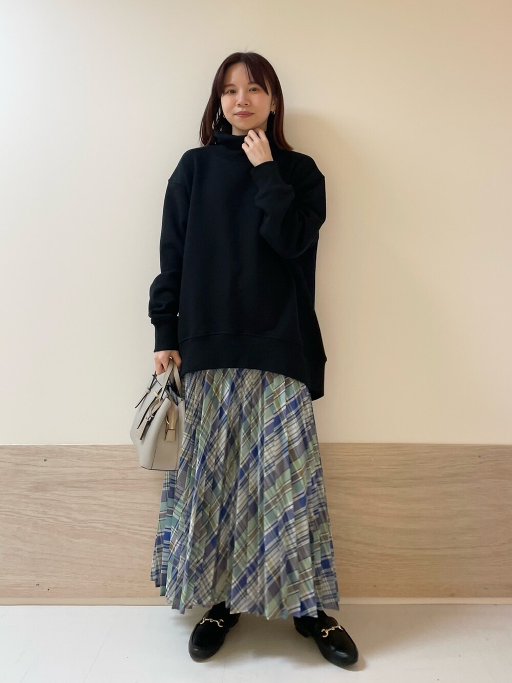 グリーン系のスカート、ブラック系のスウェットを着用したレディースの春コーディネートの3枚目の写真