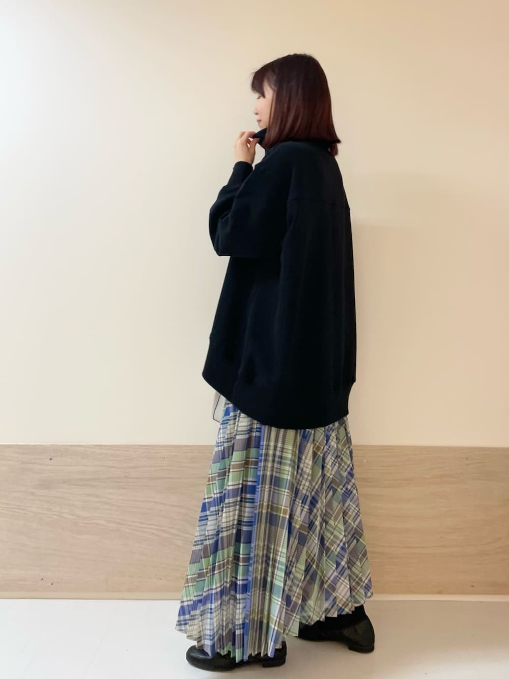 グリーン系のスカート、ブラック系のスウェットを着用したレディースの春コーディネートの4枚目の写真