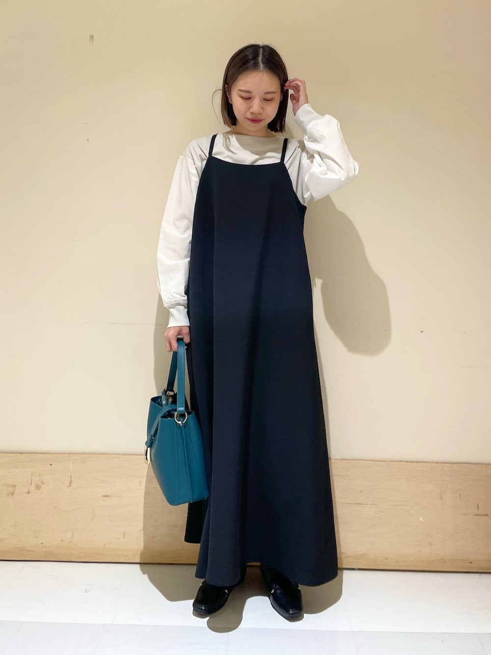 グレー系のTシャツ/カットソー、ブラック系のワンピース、ブルー系のハンドバッグを着用したレディースの秋コーディネートの3枚目の写真