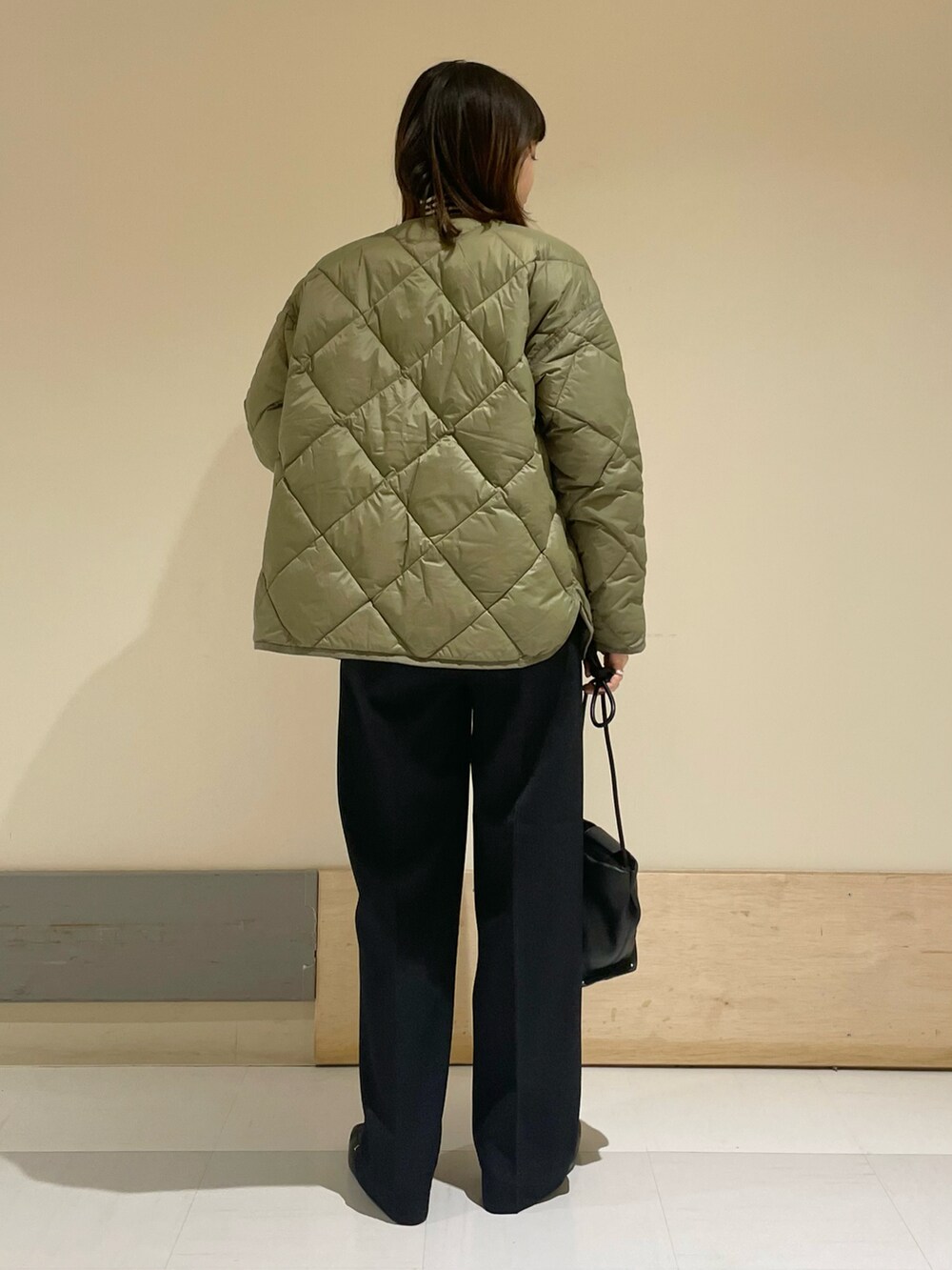 グリーン系のダウンジャケット/コート、ブラウン系のニット/セーター、ブルー系のその他パンツを着用したレディースの冬コーディネートの3枚目の写真