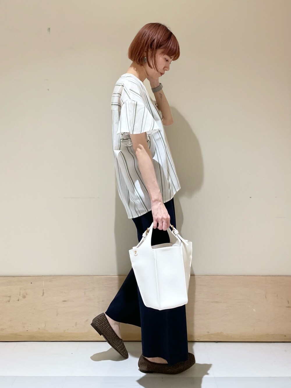 グリーン系のシャツ/ブラウス、ブルー系のその他パンツ、ホワイト系のトートバッグを着用したレディースの春コーディネートの4枚目の写真