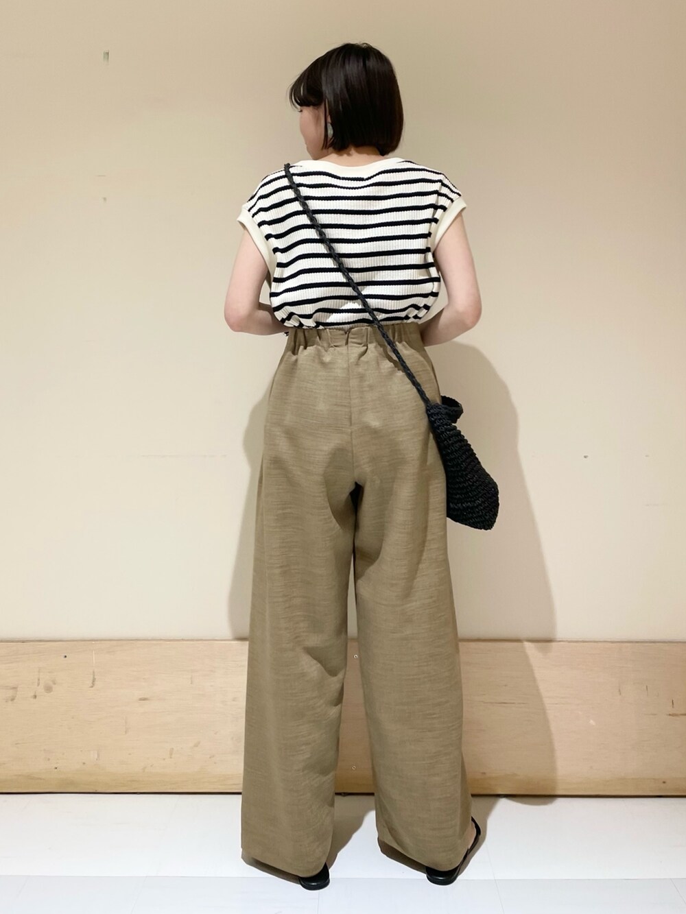 ベージュ系のその他パンツ、ブラック系のショルダーバッグ、ホワイト系のTシャツ/カットソーを着用したレディースの夏コーディネートの6枚目の写真