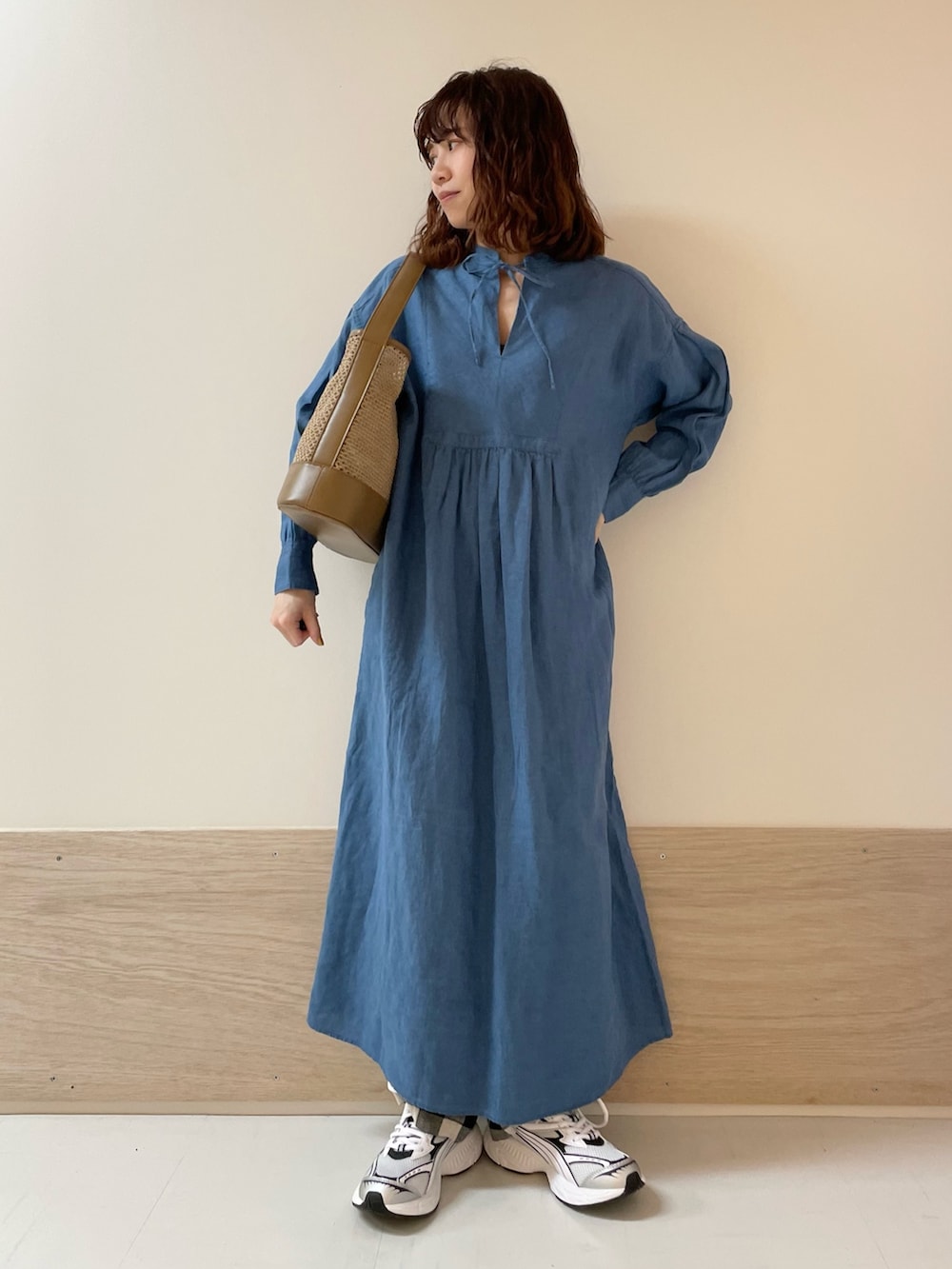 ブラック系のその他パンツ、ブルー系のワンピース、ベージュ系のショルダーバッグを着用したレディースの春コーディネートの3枚目の写真