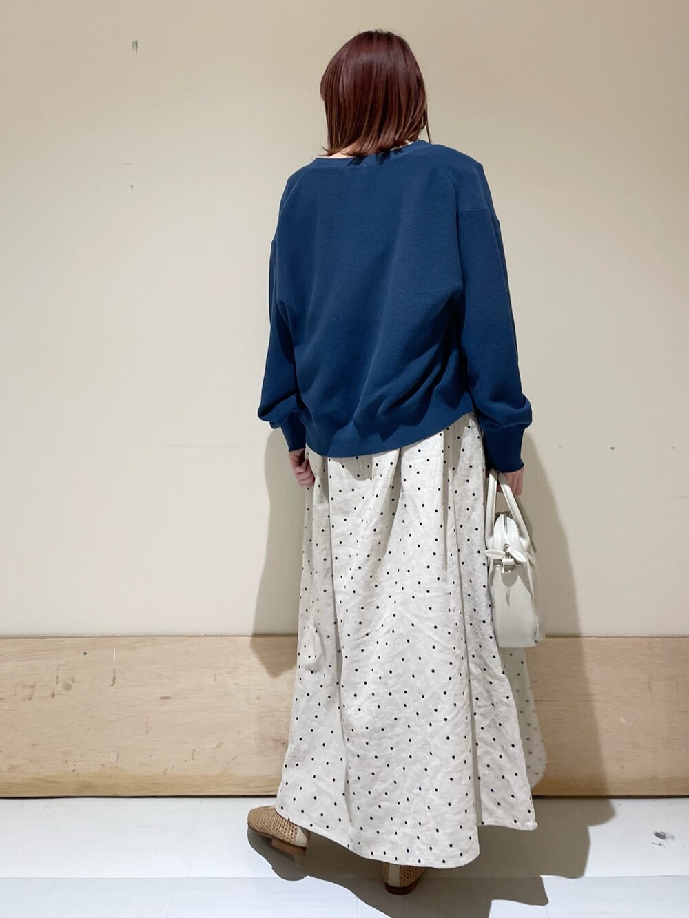 ベージュ系のショルダーバッグ、ベージュ系のパンプス、ブルー系のニット/セーターを着用したレディースの春コーディネートの6枚目の写真