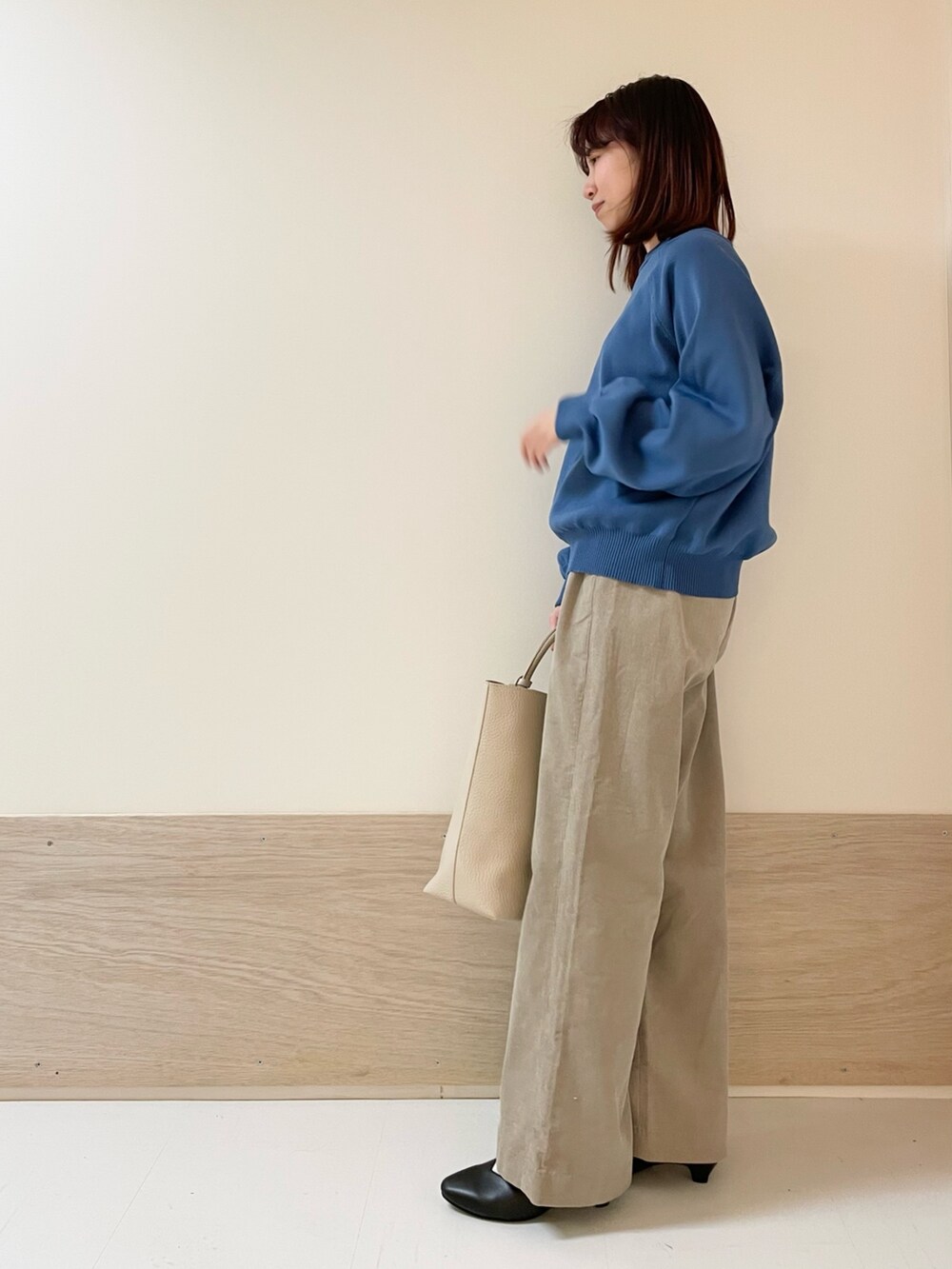 ブルー系のニット/セーター、ベージュ系のその他パンツ、ブラック系のパンプスを着用したレディースの冬コーディネートの4枚目の写真