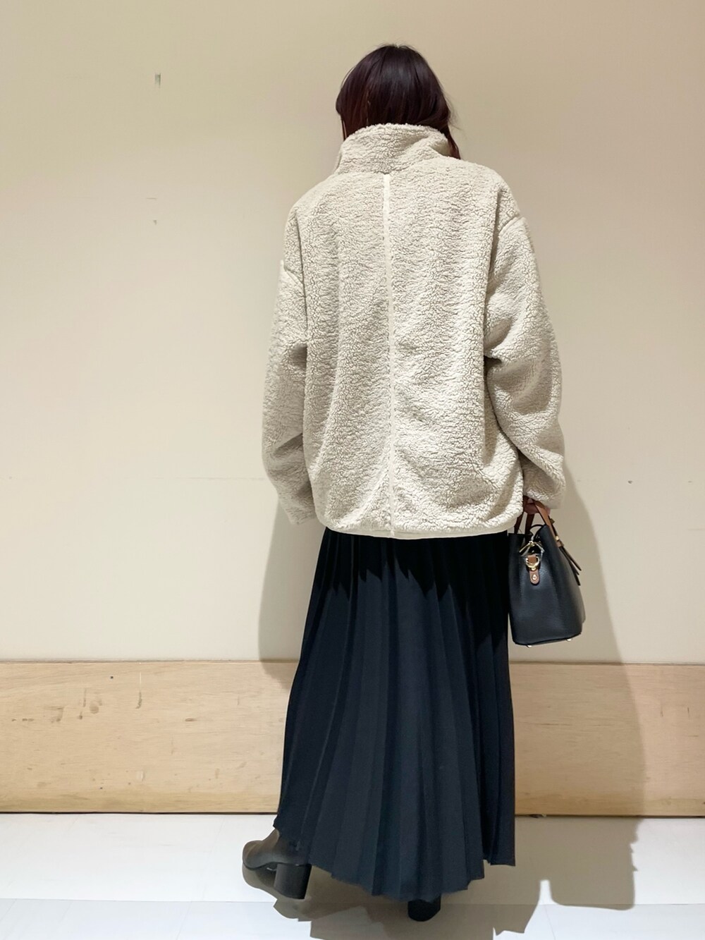 ピンク系のニット/セーター、ホワイト系のブルゾン、ブラック系のスカートを着用したレディースの冬コーディネートの6枚目の写真