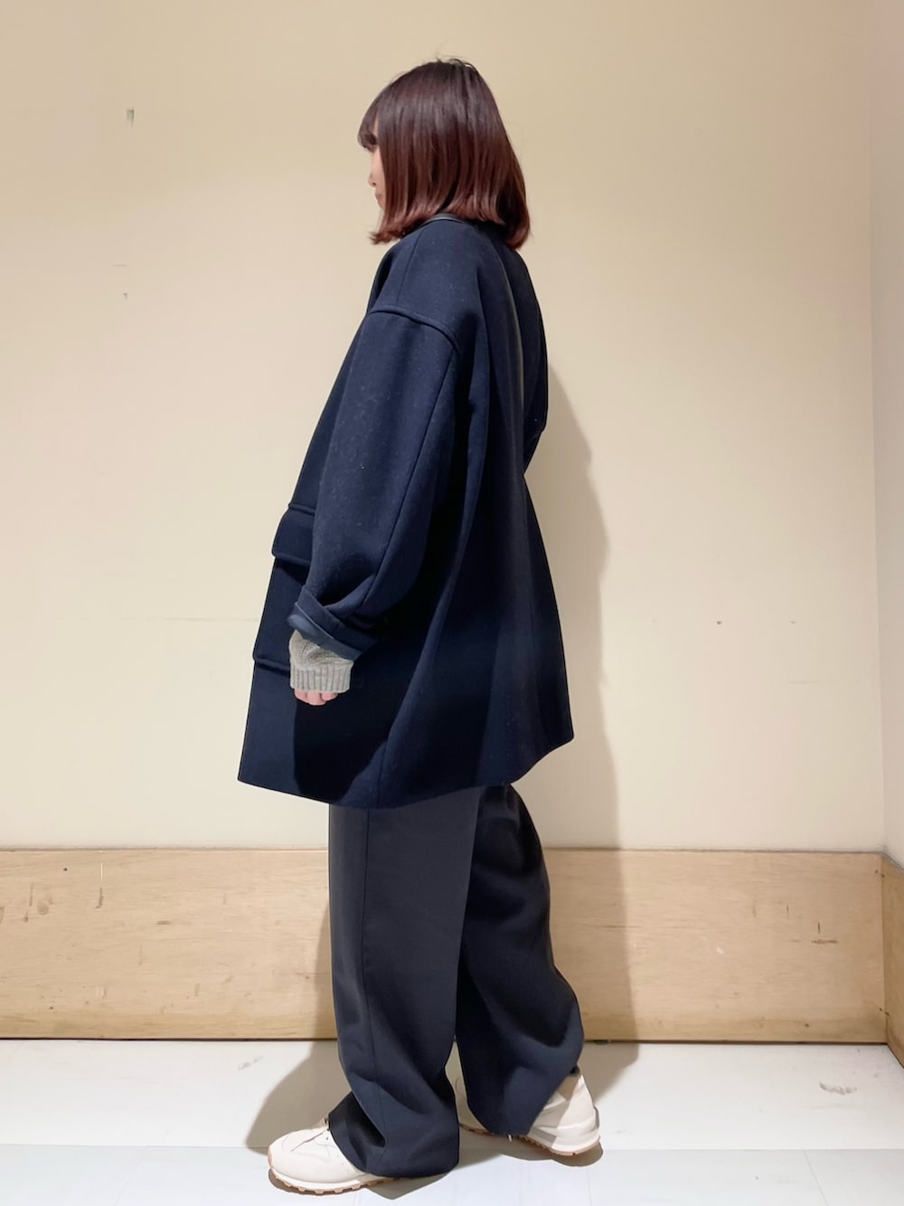 グレー系のニット/セーター、ブルー系のその他アウター、ブラック系のショルダーバッグを着用したレディースの冬コーディネートの4枚目の写真