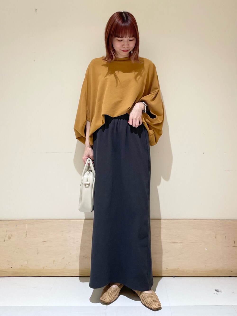 イエロー系のTシャツ/カットソー、ベージュ系のパンプス、グレー系のスカートを着用したレディースの春コーディネートの3枚目の写真