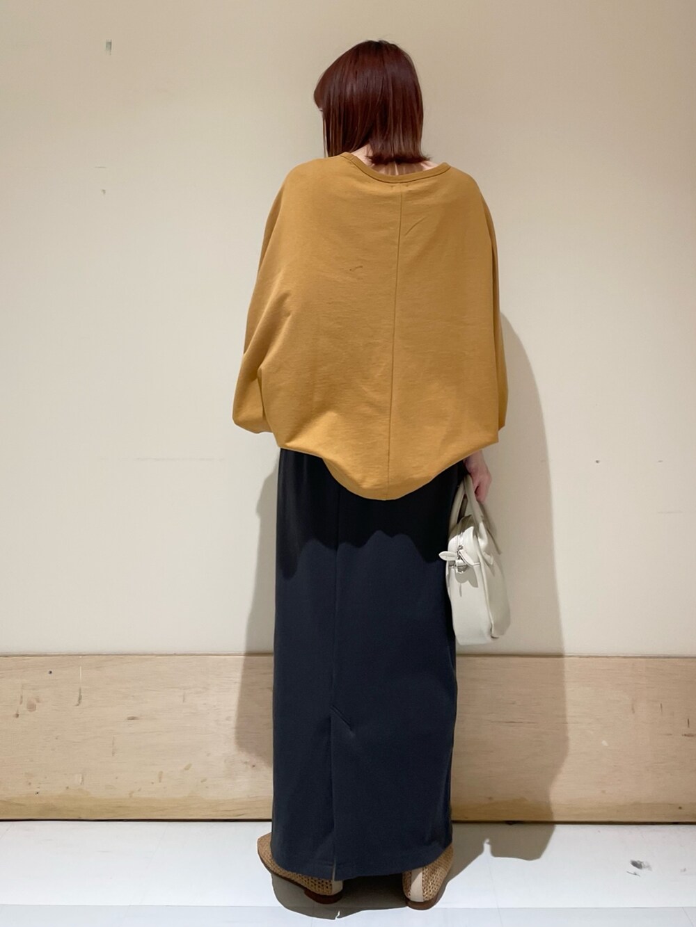 イエロー系のTシャツ/カットソー、ベージュ系のパンプス、グレー系のスカートを着用したレディースの春コーディネートの8枚目の写真