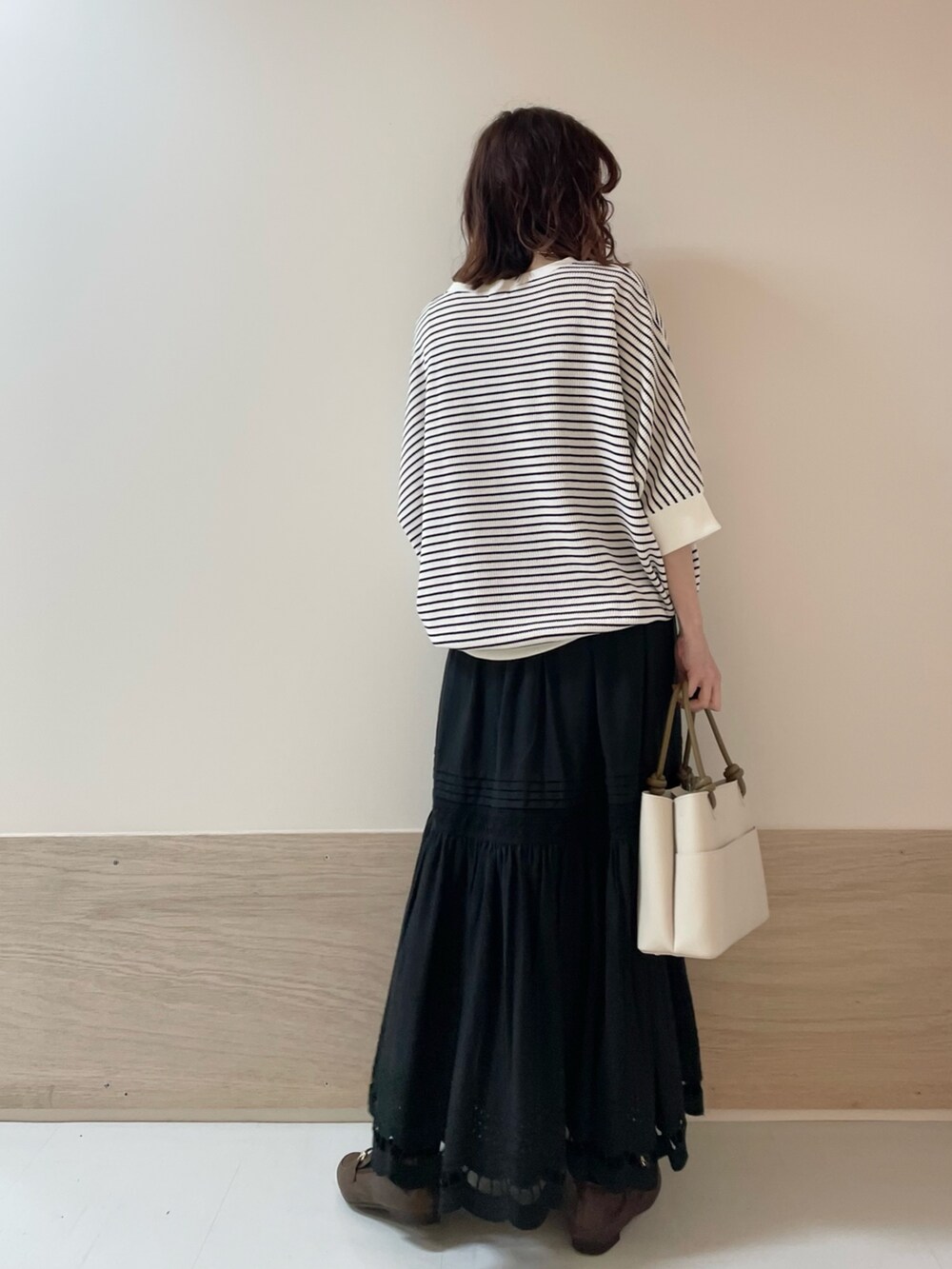 ブラウン系のローファー、ブラック系のスカート、ホワイト系のTシャツ/カットソーを着用したレディースの春コーディネートの6枚目の写真