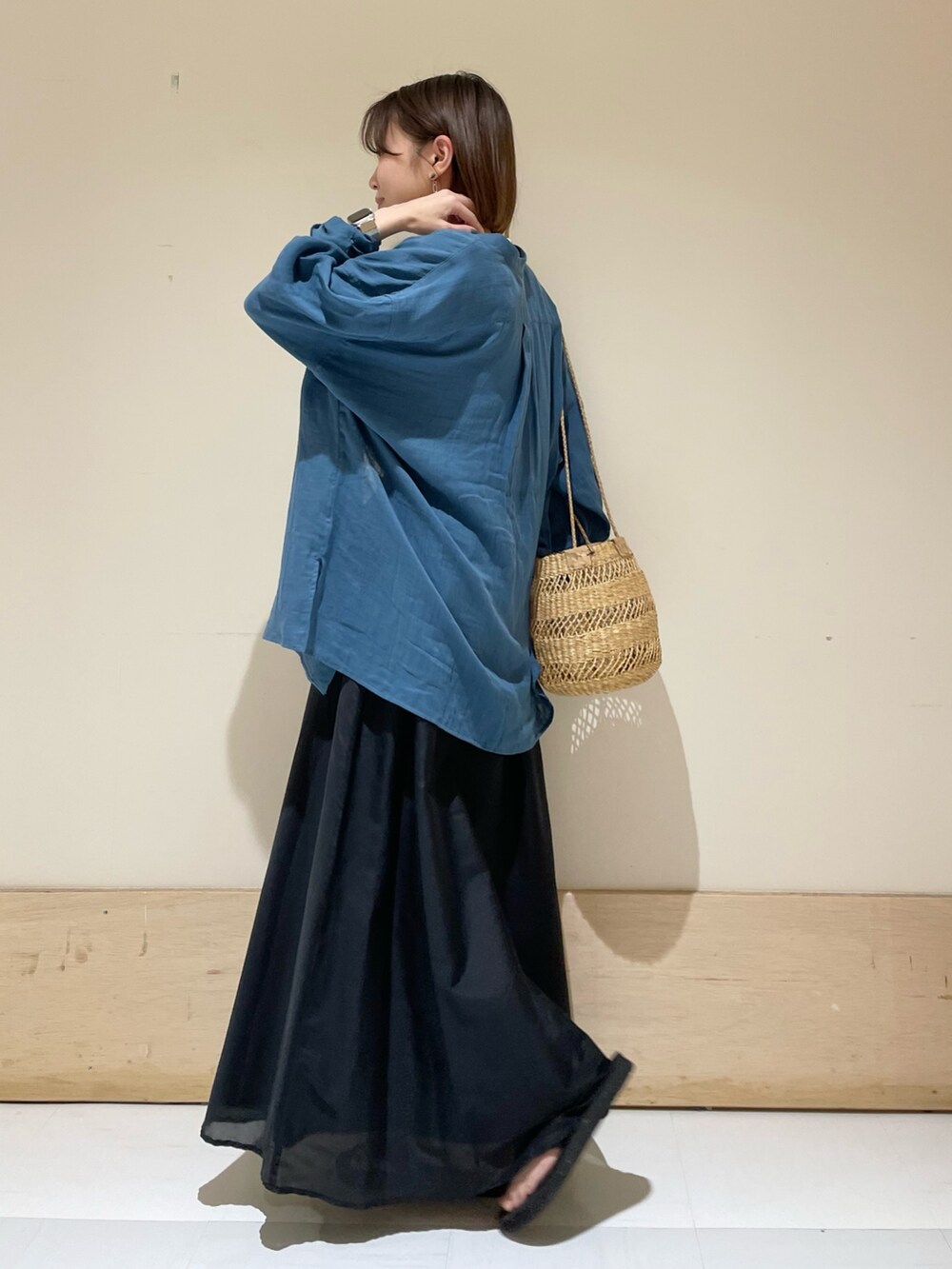 ブラック系のスカート、ベージュ系のショルダーバッグ、グレー系のTシャツ/カットソーを着用したレディースの夏コーディネートの4枚目の写真