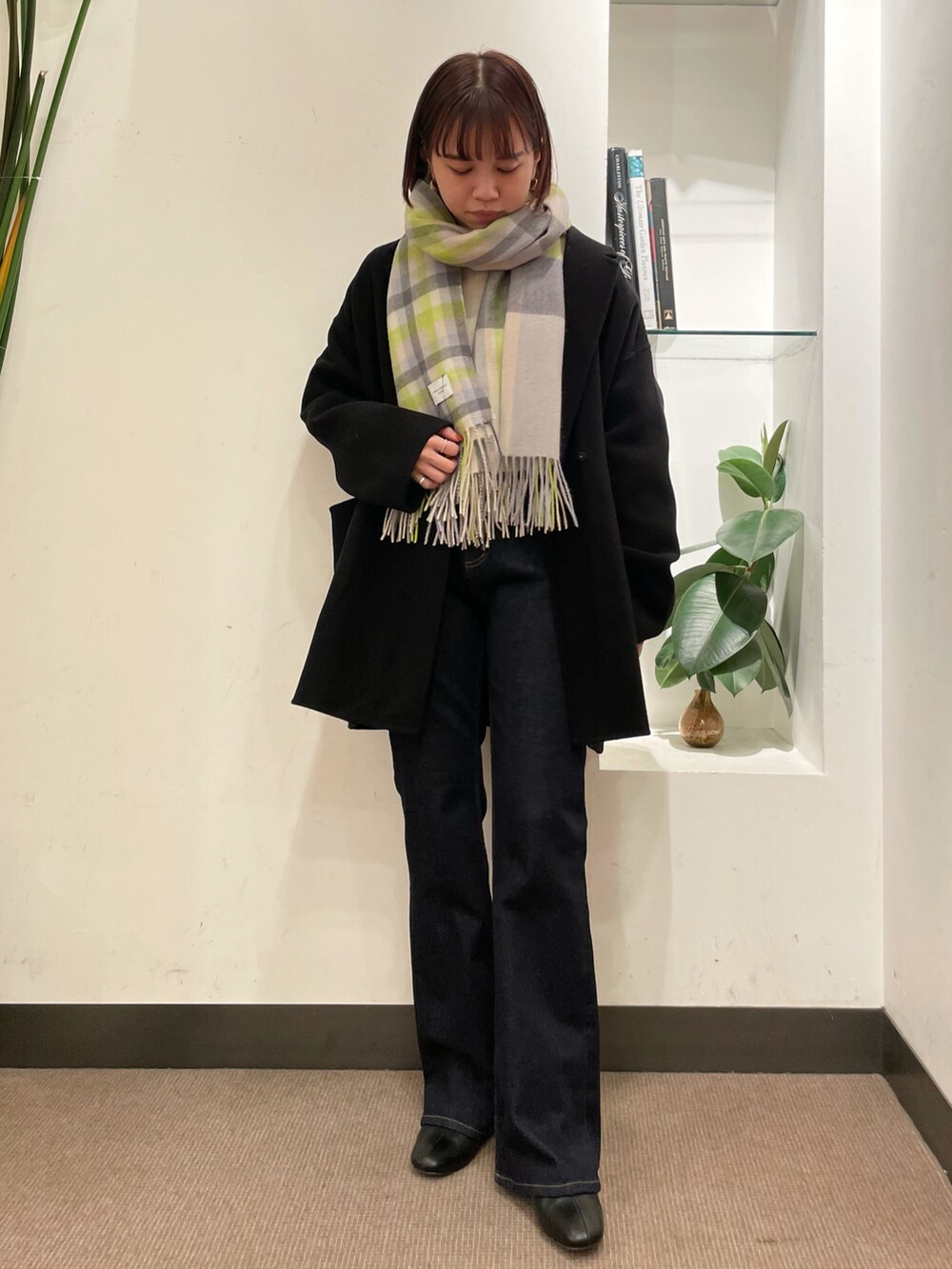 ブルー系のデニムパンツ、ブラック系のその他アウター、ホワイト系のニット/セーターを着用したレディースの冬コーディネートの2枚目の写真