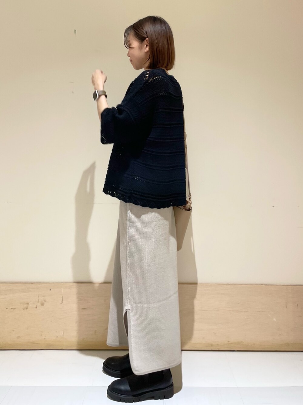 ベージュ系のショルダーバッグ、ブラック系のブーツ、ブラック系のニット/セーターを着用したレディースの秋コーディネートの3枚目の写真