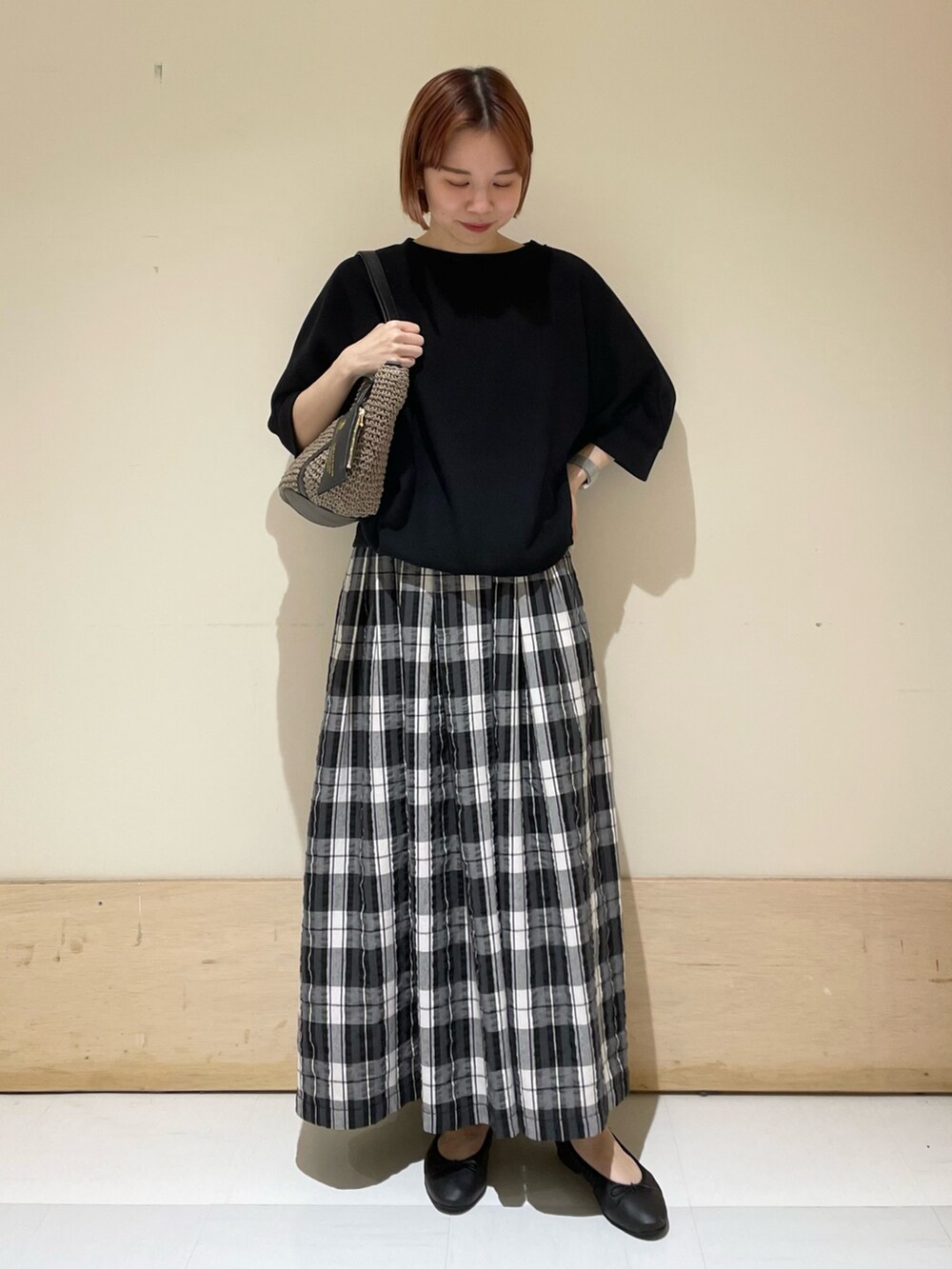 ブラック系のTシャツ/カットソー、ブラック系のスカート、グレー系のトートバッグを着用したレディースの春コーディネートの4枚目の写真