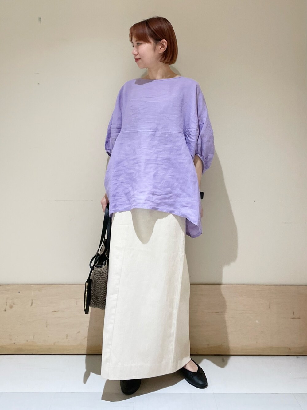 パープル系のシャツ/ブラウス、ベージュ系のスカート、グレー系のトートバッグを着用したレディースの春コーディネートの2枚目の写真