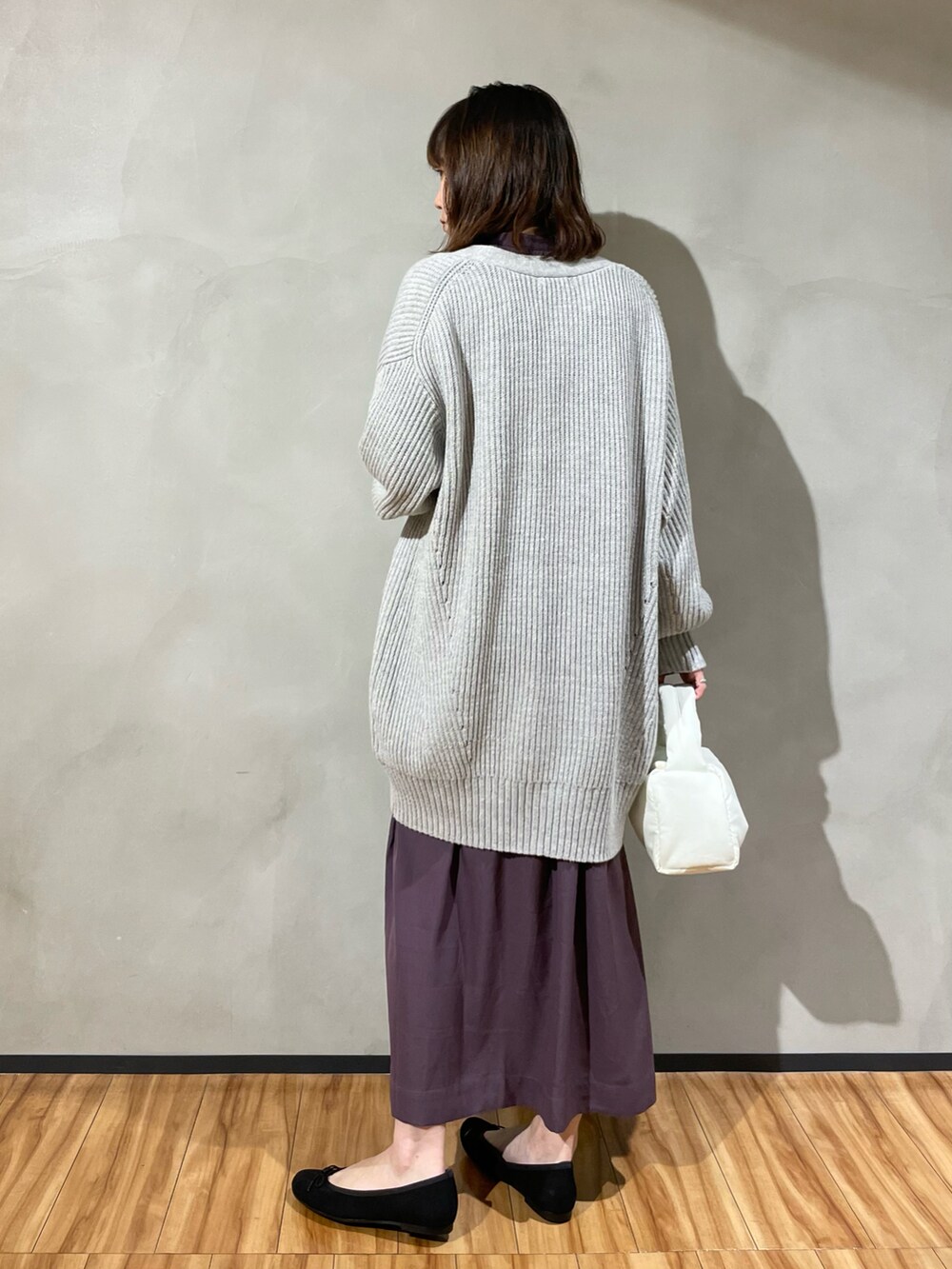 ブラック系のバレエシューズ、パープル系のワンピース、ホワイト系のカーディガン/ボレロを着用したレディースの秋コーディネートの3枚目の写真