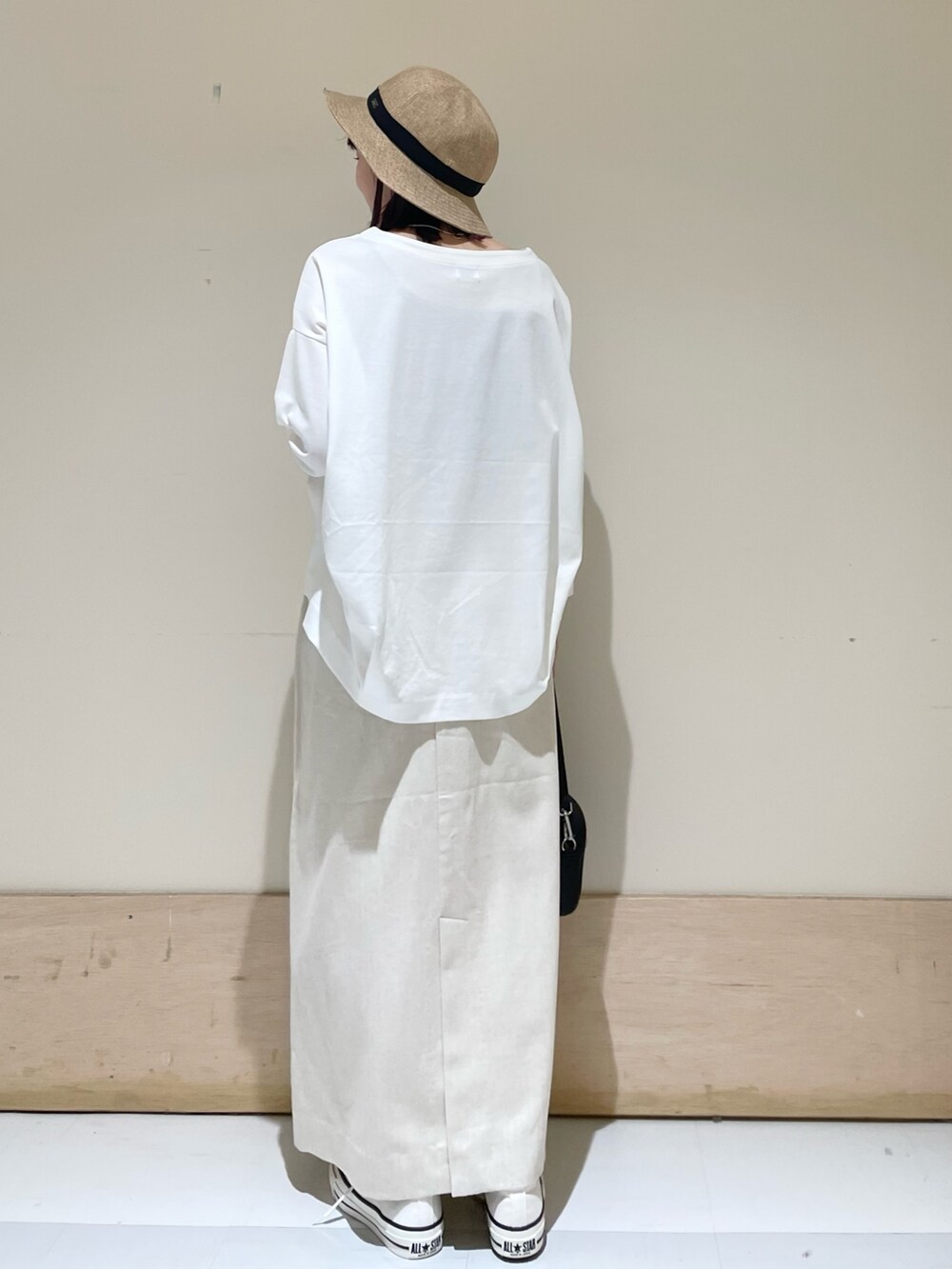 ホワイト系のTシャツ/カットソー、ホワイト系のスニーカー、ブラック系のショルダーバッグを着用したレディースの春コーディネートの5枚目の写真